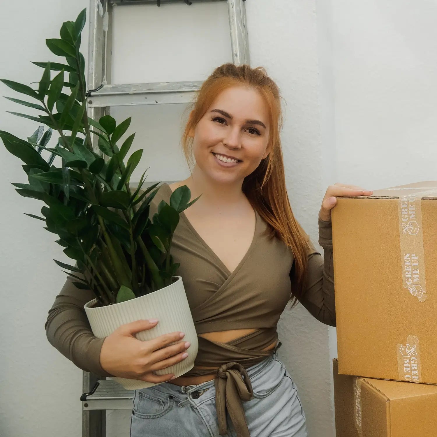 Glückliche Frau mit zamio Pflanze